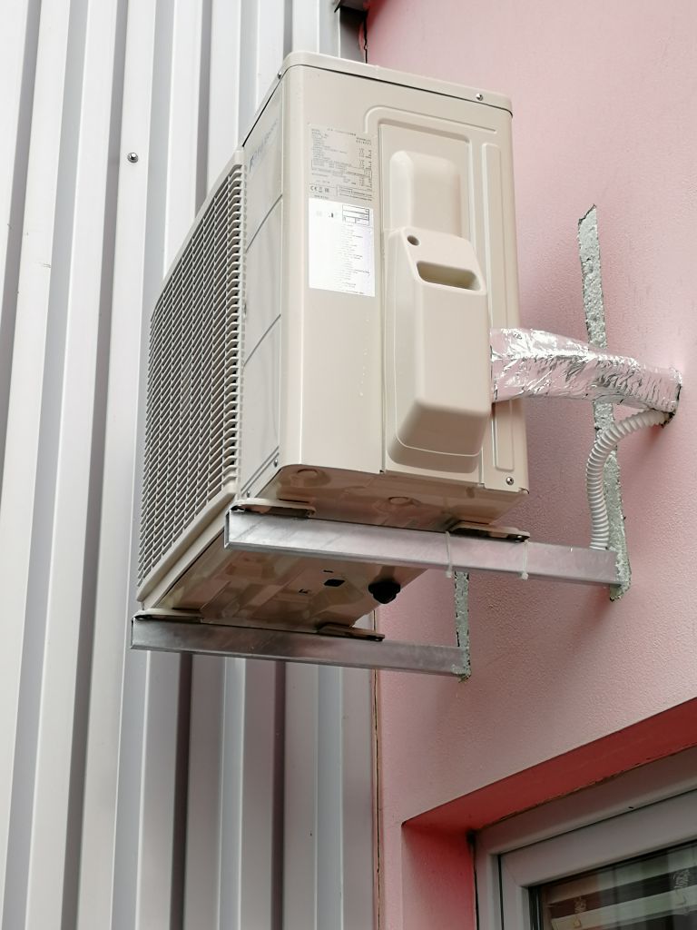 Nainstalovaná venkovní jednotka klimatizace FUJI - zapěnění a seříznutí pěny s hranou fasády.